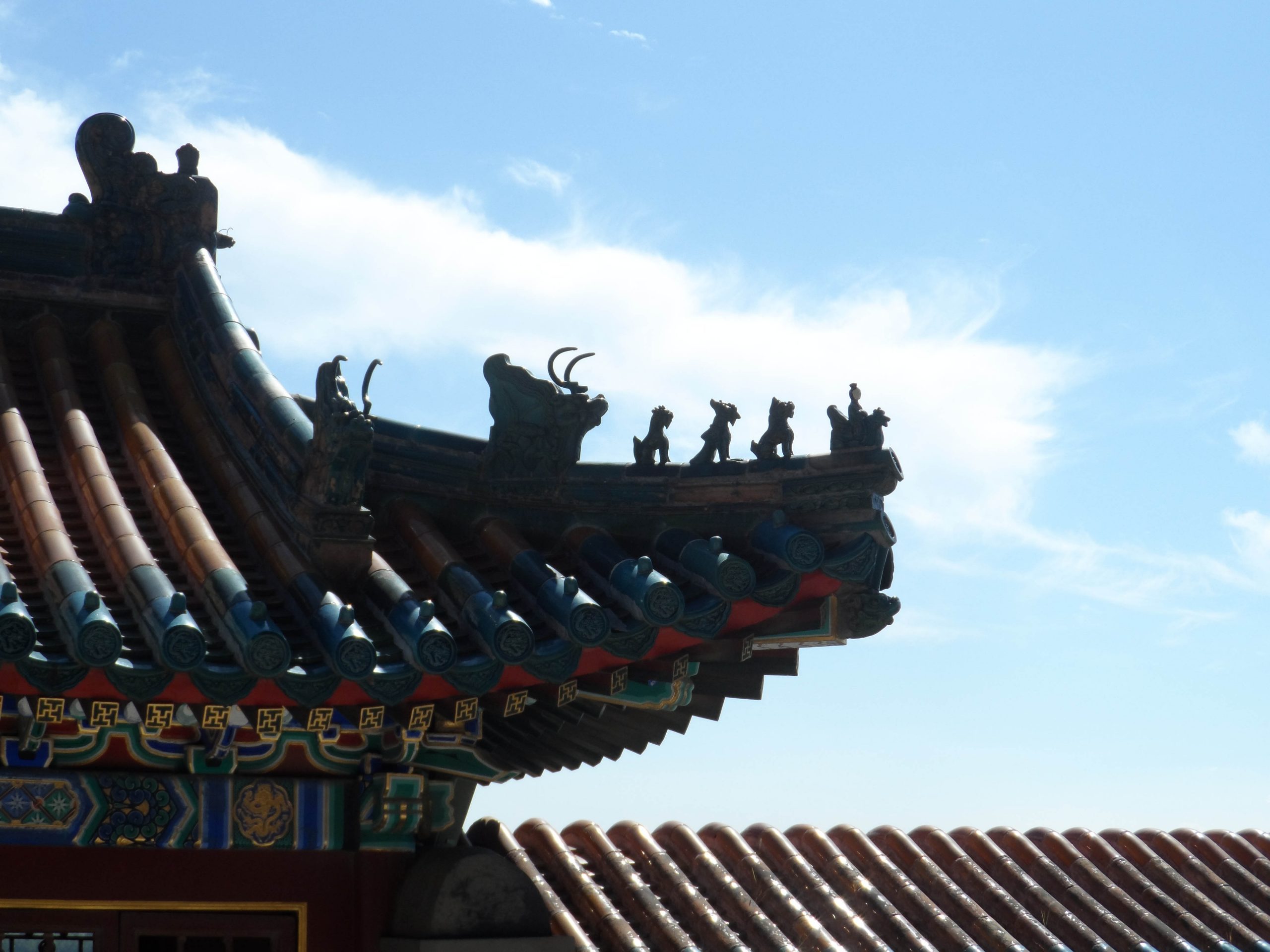 Close up of a dragon design on a flared eve of the palace roof